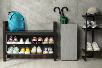 Photo of Shoe storage bench with different footwear and other accessories indoors