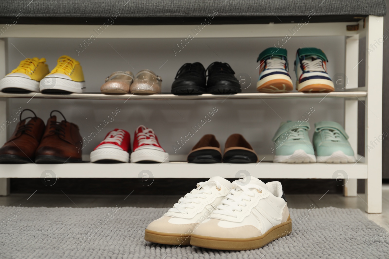 Shoe storage bench with different footwear indoors Photo of Shoe storage bench with different footwear indoors