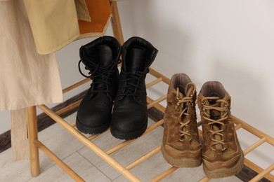 Photo of Shoe storage. Wooden rack with footwear indoors, closeup
