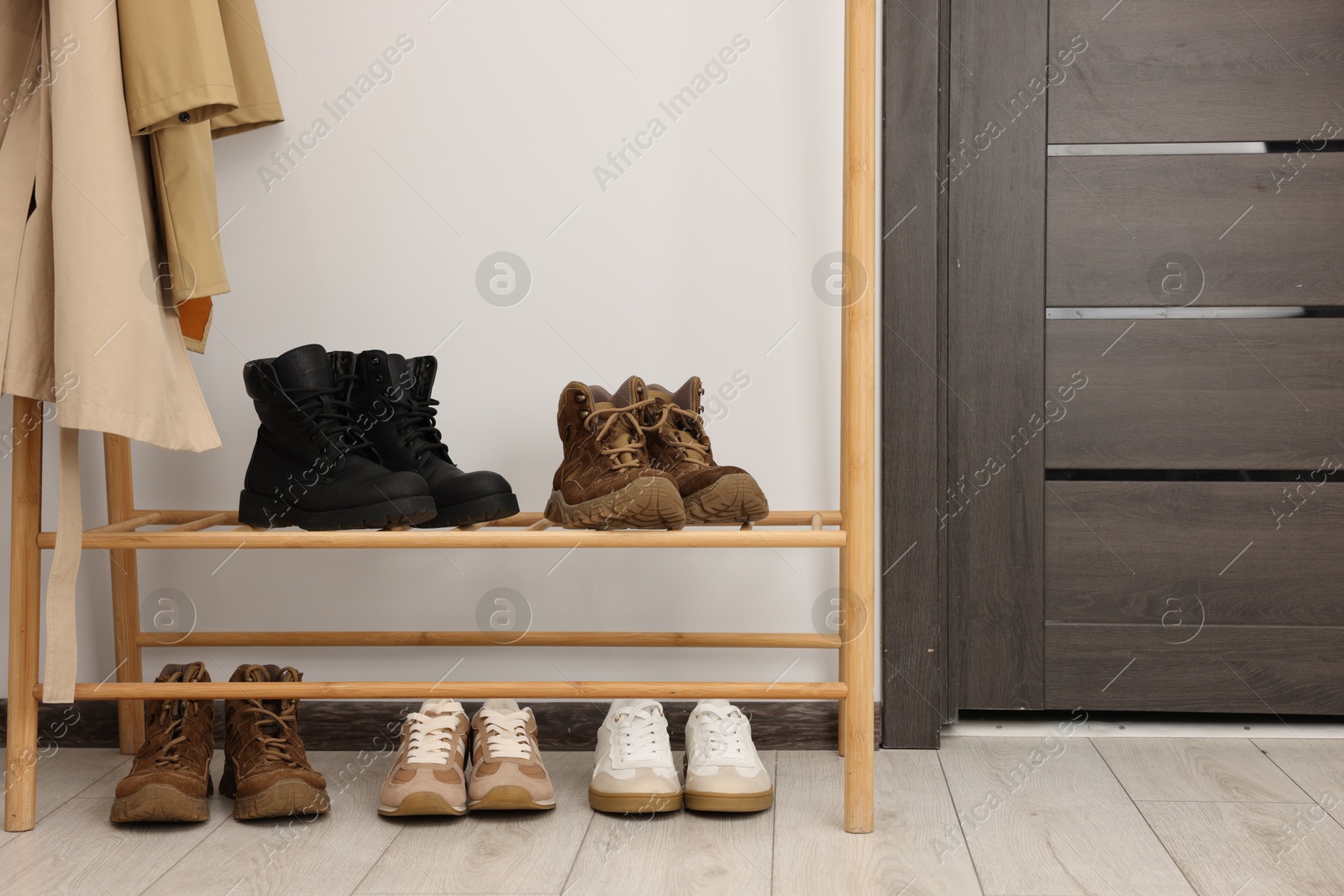 Shoe storage. Wooden rack with different footwear indoors Photo of Shoe storage. Wooden rack with different footwear indoors