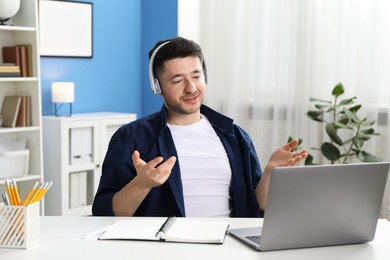 Photo of Man having online lesson with teacher via laptop at desk indoors