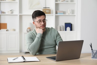 Photo of Man learning online using laptop at desk indoors. Self-study