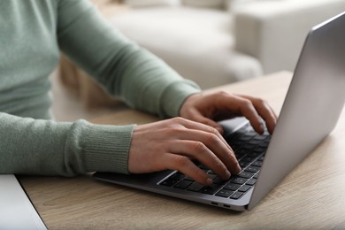 Photo of Man using laptop at desk indoors, closeup