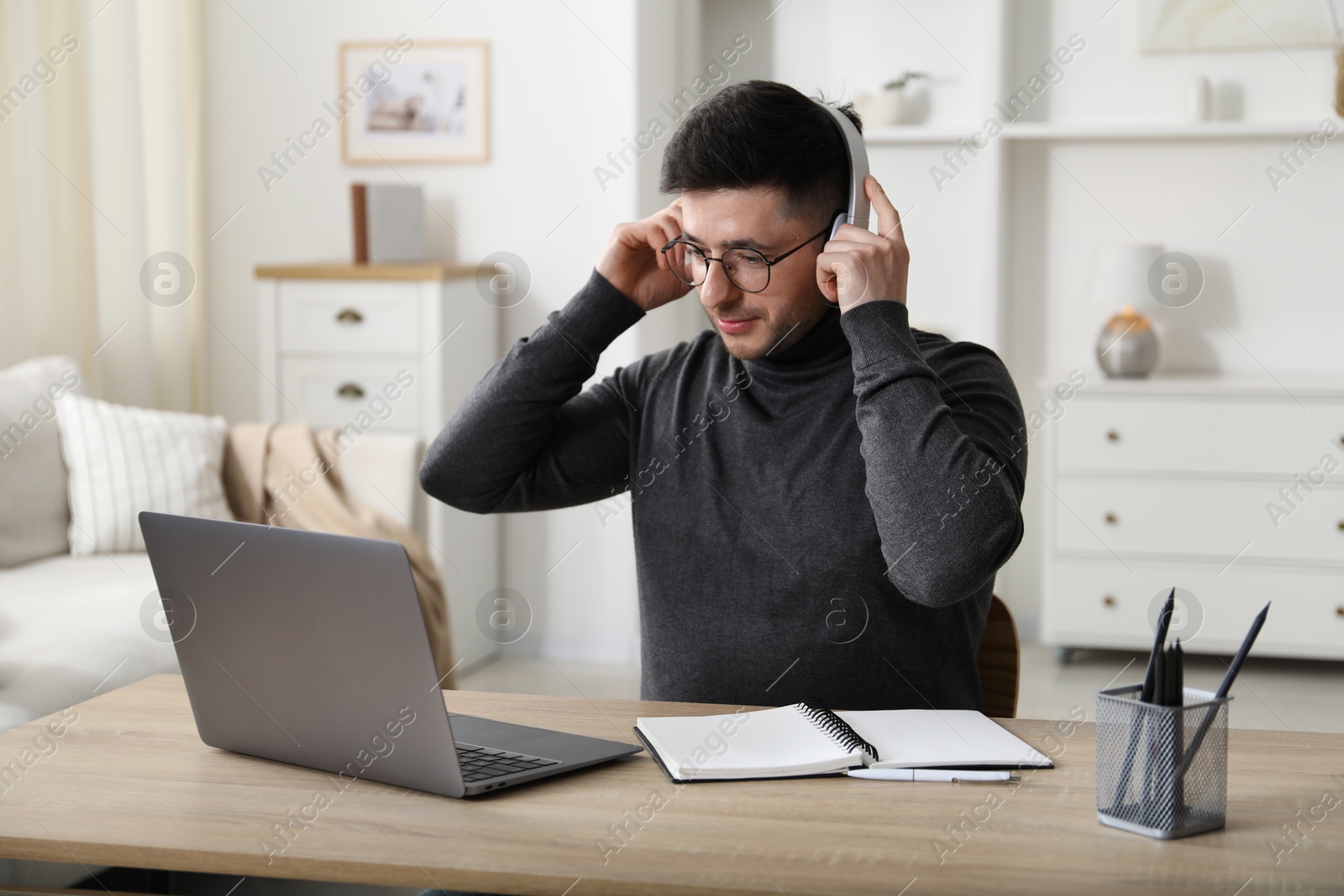 Photo of Man learning online using laptop at desk indoors. Self-study