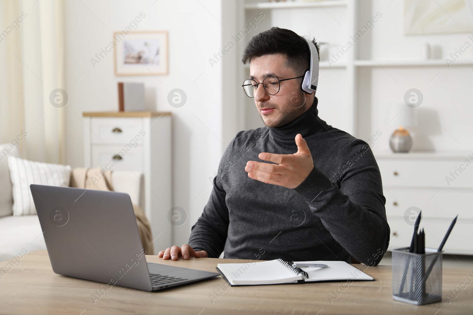 Photo of Man having online lesson with teacher via laptop at desk indoors