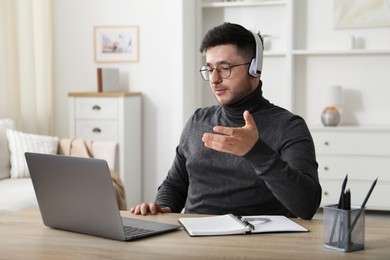 Photo of Man having online lesson with teacher via laptop at desk indoors