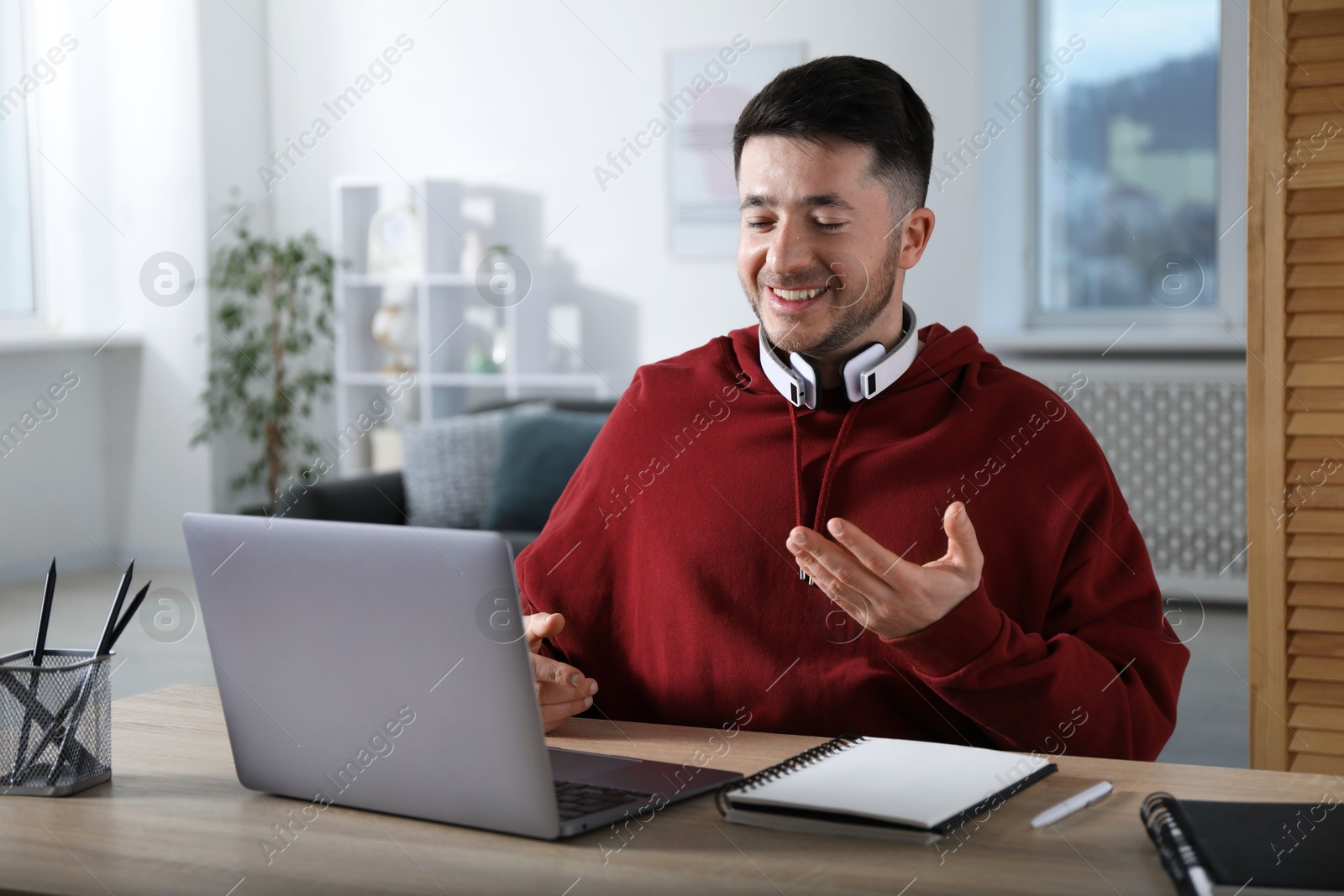 Photo of Man having online lesson with teacher via laptop at desk indoors