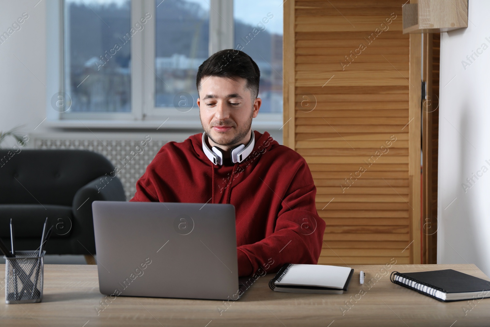 Photo of Man learning online using laptop at desk indoors. Self-study