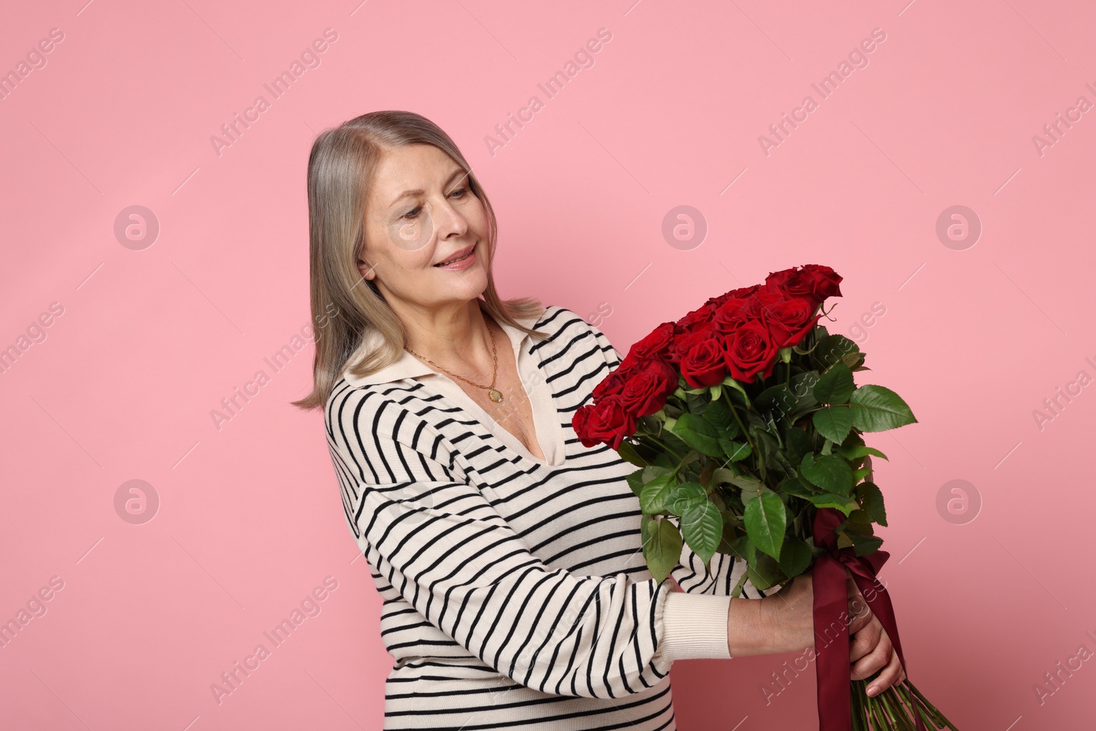 Photo of Beautiful woman with bouquet of roses on pink background