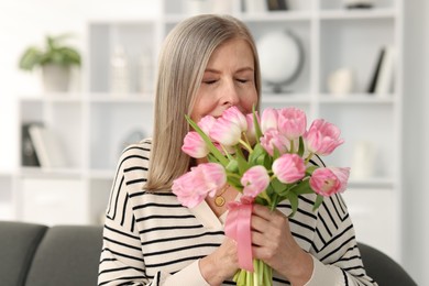 Beautiful woman with bouquet of tulips at home