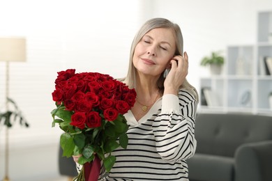 Photo of Beautiful woman with bouquet of roses at home