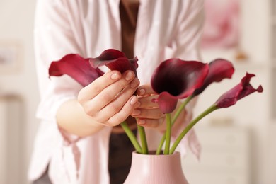 Photo of Woman with bouquet of calla lily flowers indoors, closeup