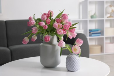 Photo of Beautiful tulips in vases on table indoors