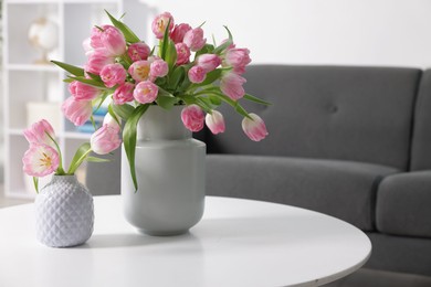 Photo of Beautiful tulips in vases on table indoors. Space for text