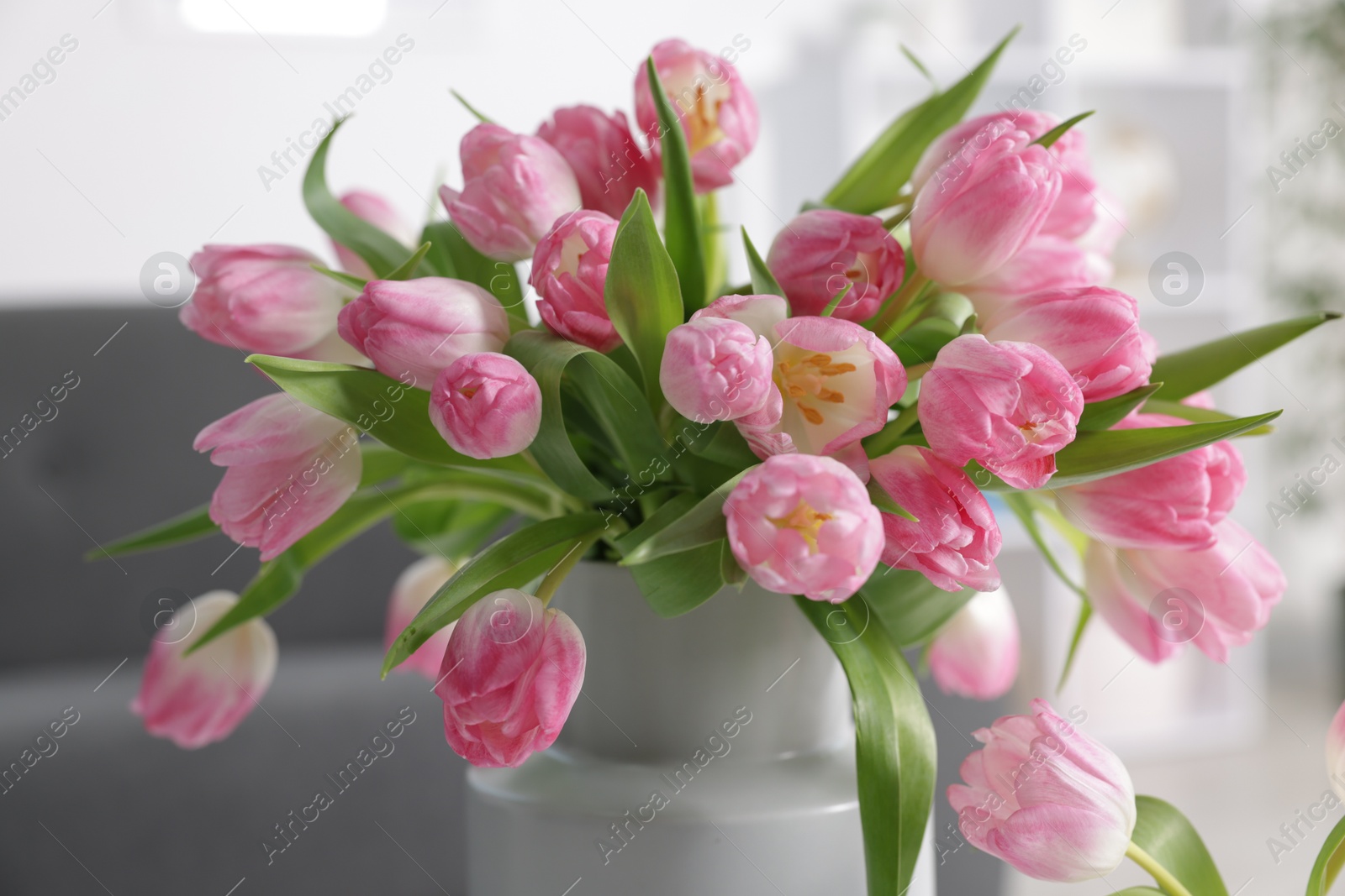 Photo of Bouquet of beautiful tulips in vase indoors, closeup