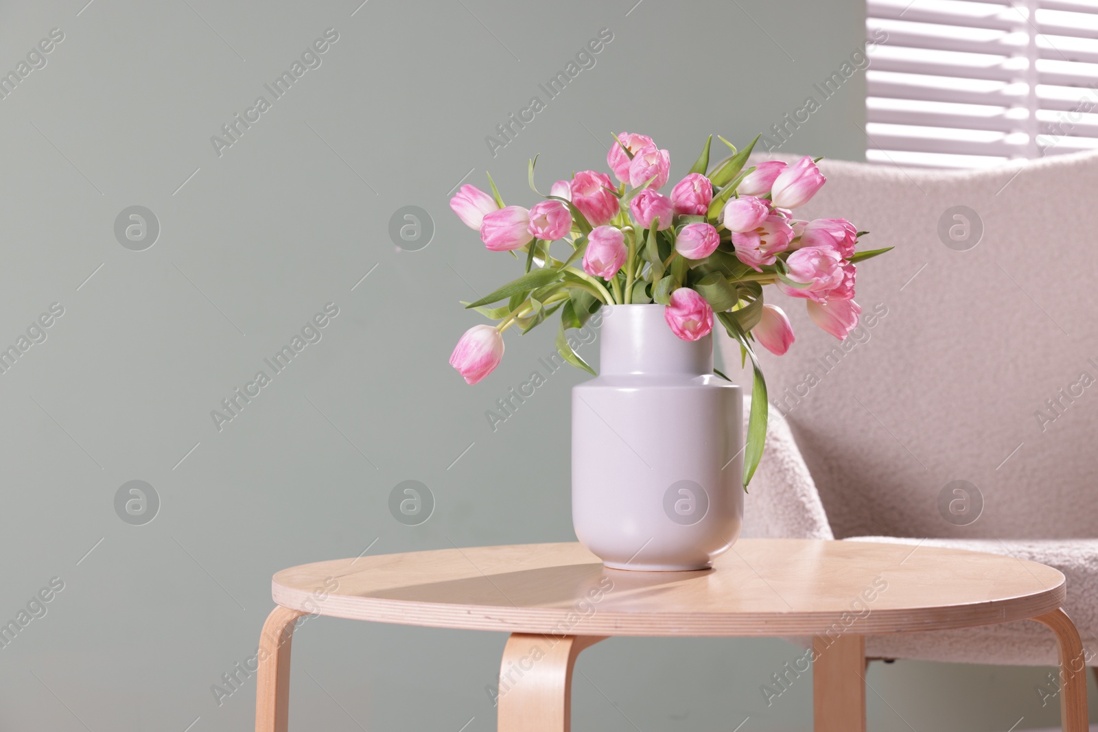 Photo of Bouquet of beautiful tulips in vase on table indoors. Space for text