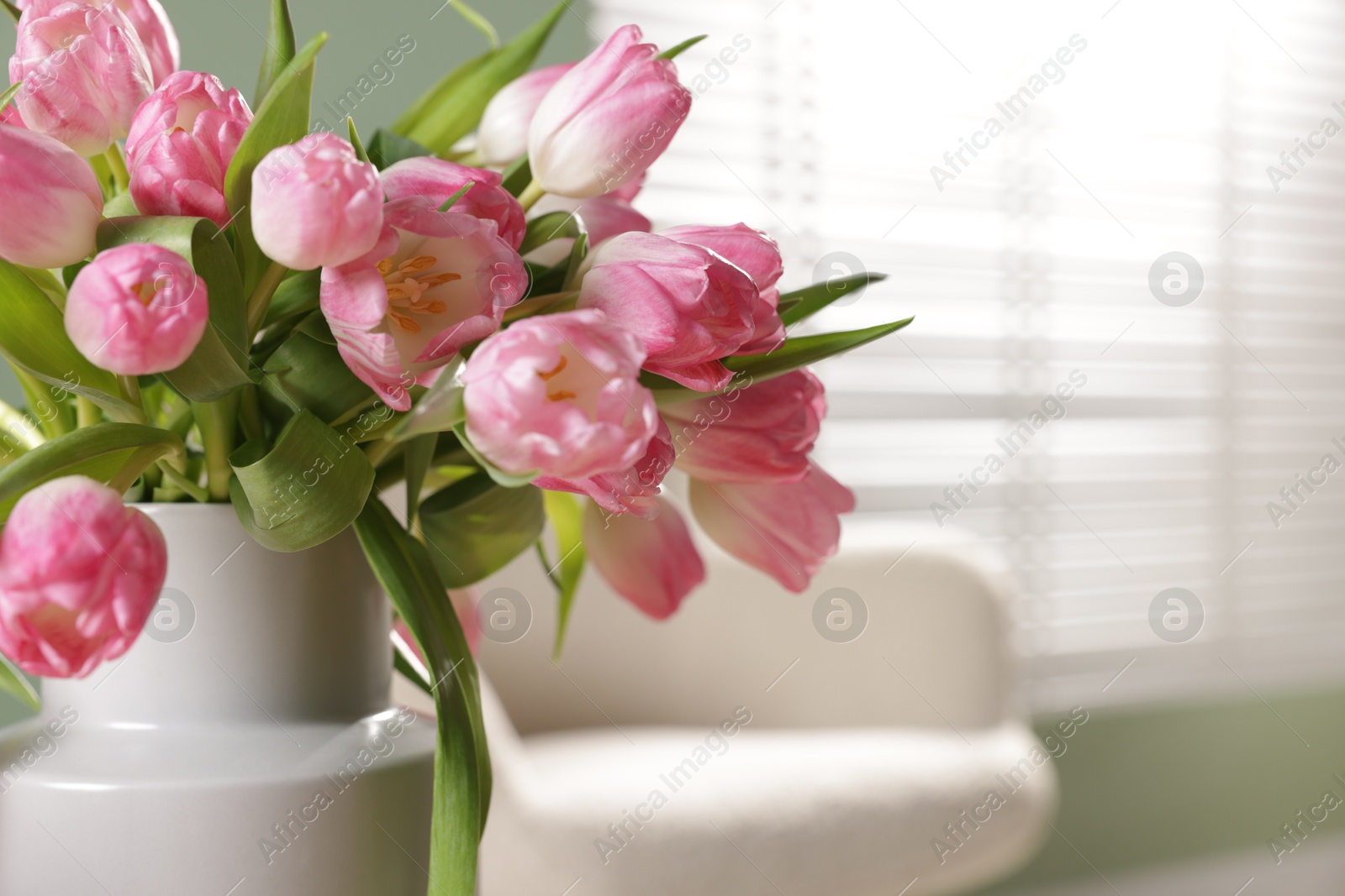 Photo of Bouquet of beautiful tulips in vase indoors, closeup. Space for text