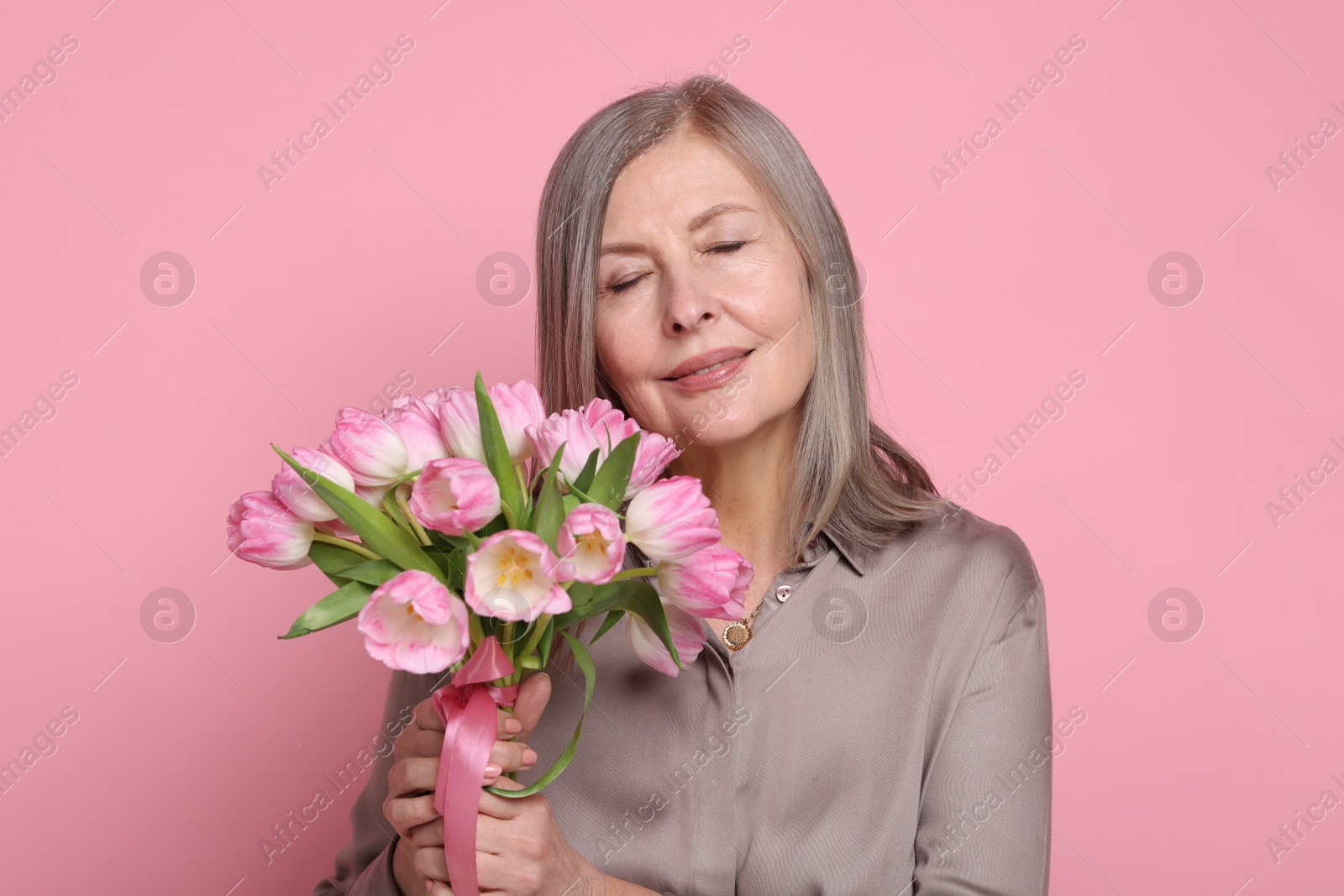 Photo of Beautiful woman with bouquet of tulips on pink background