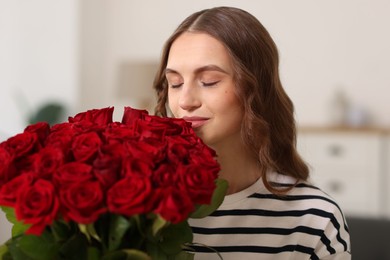 Photo of Beautiful woman with bouquet of roses at home