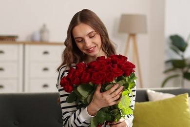 Photo of Smiling woman with bouquet of roses at home