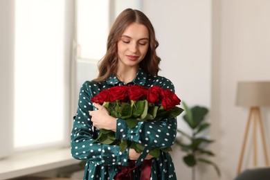 Photo of Beautiful woman with bouquet of roses at home