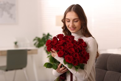 Photo of Smiling woman with bouquet of roses at home. Space for text