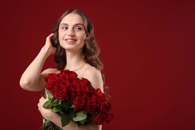 Photo of Smiling woman with bouquet of roses on dark red background. Space for text