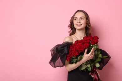 Photo of Smiling woman with bouquet of roses on pink background. Space for text