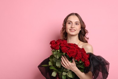 Photo of Smiling woman with bouquet of roses on pink background. Space for text