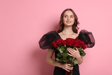 Photo of Smiling woman with bouquet of roses on pink background. Space for text