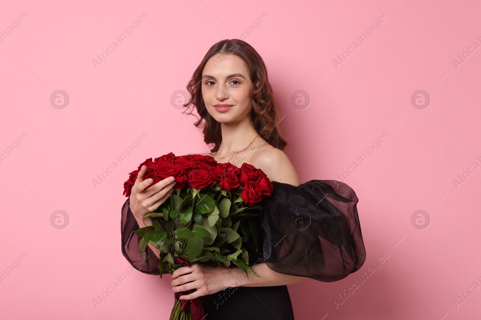 Photo of Beautiful woman with bouquet of roses on pink background