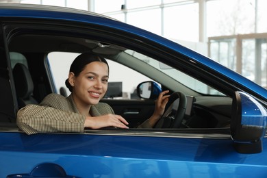 Photo of Happy woman inside new car in salon