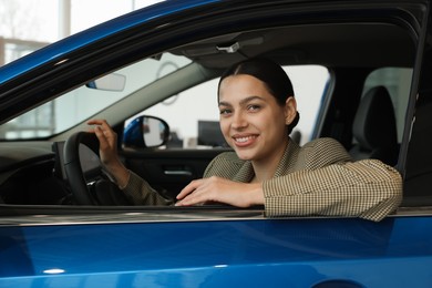 Photo of Happy woman inside new car in salon