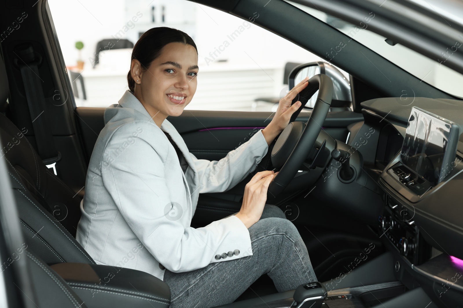 Photo of Happy woman inside new car in salon