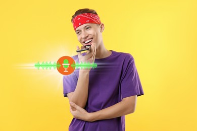 Young man recording voice message via smartphone on yellow background. Illustration of microphone and sound waves