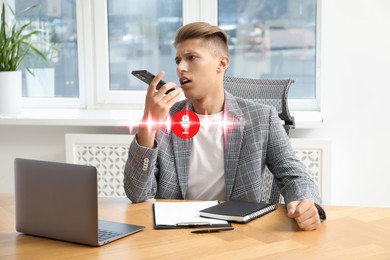 Young man recording voice message via smartphone in office. Illustration of microphone and sound waves