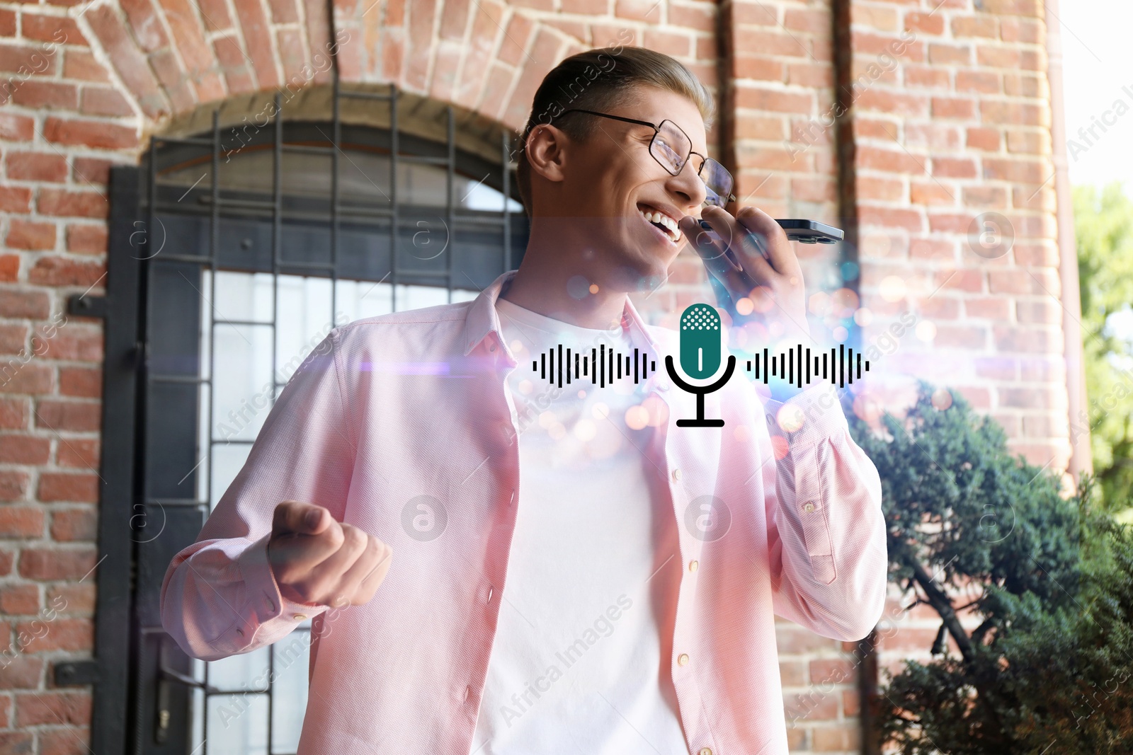 Image of Young man recording voice message via smartphone outdoors. Illustration of microphone and sound waves