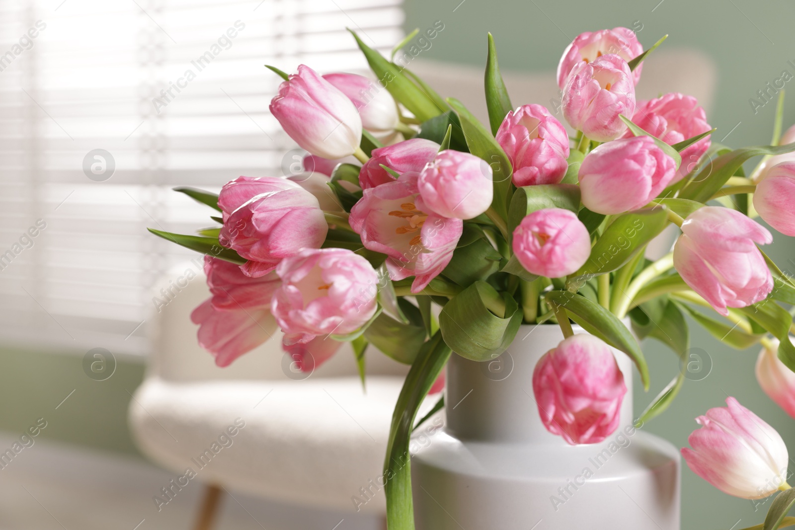 Photo of Bouquet of beautiful tulips in vase indoors, closeup