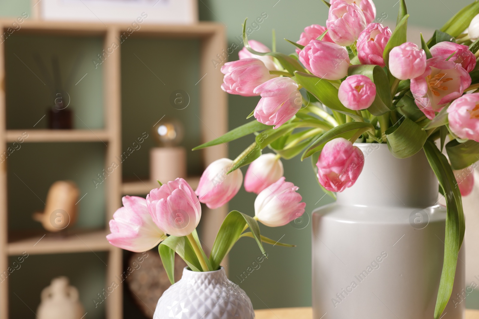 Photo of Bouquets of beautiful tulips in vases indoors, closeup