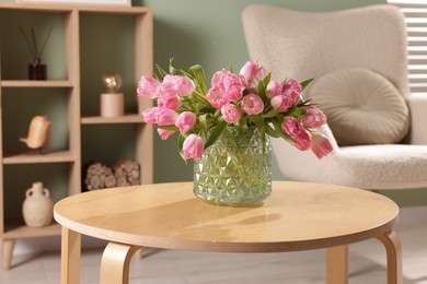 Photo of Beautiful tulips in vase on coffee table indoors