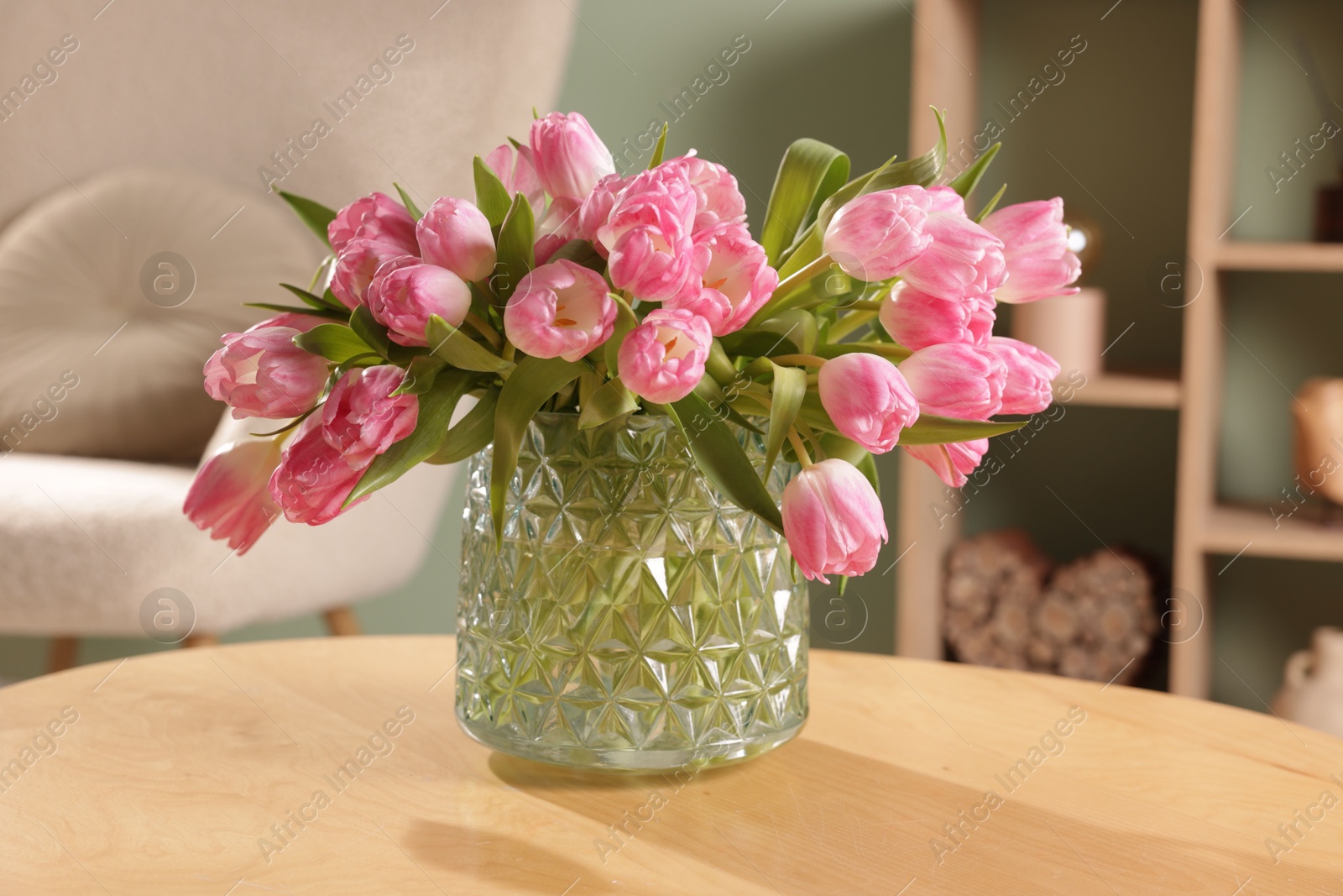 Photo of Beautiful tulips in vase on wooden table indoors, closeup