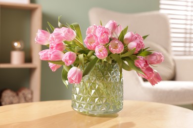 Photo of Beautiful tulips in vase on wooden table indoors, closeup