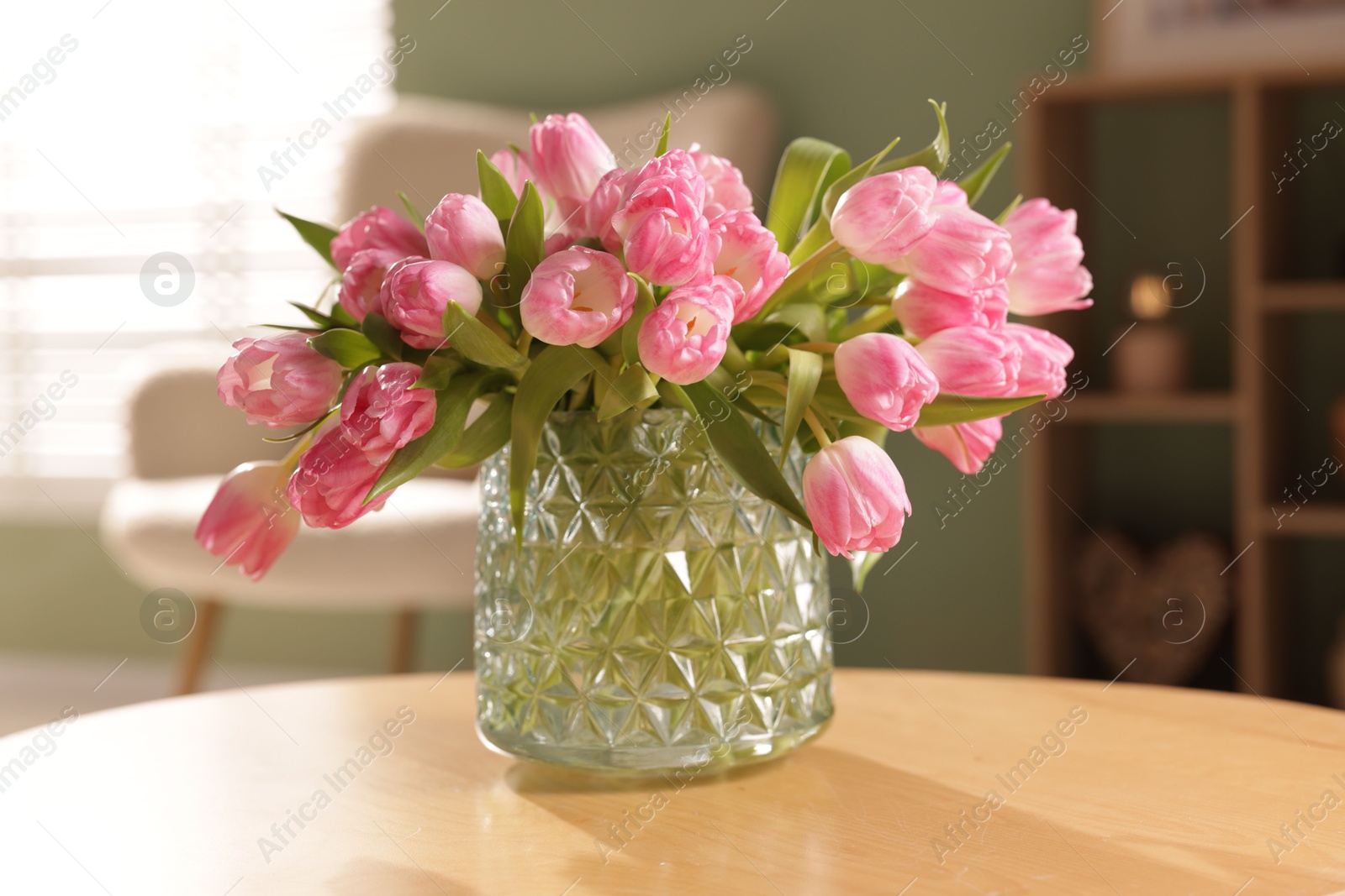 Photo of Beautiful tulips in vase on wooden table indoors, closeup