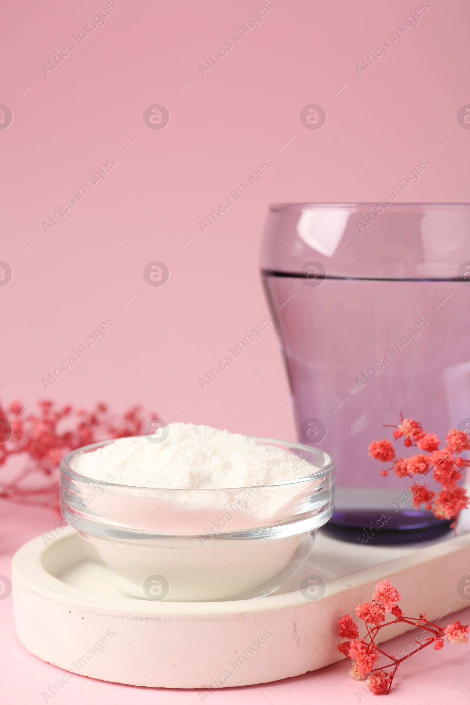 Collagen powder in bowl, glass of water and gypsophila branches on pink background, closeup Photo of Collagen powder in bowl, glass of water and gypsophila branches on pink background, closeup
