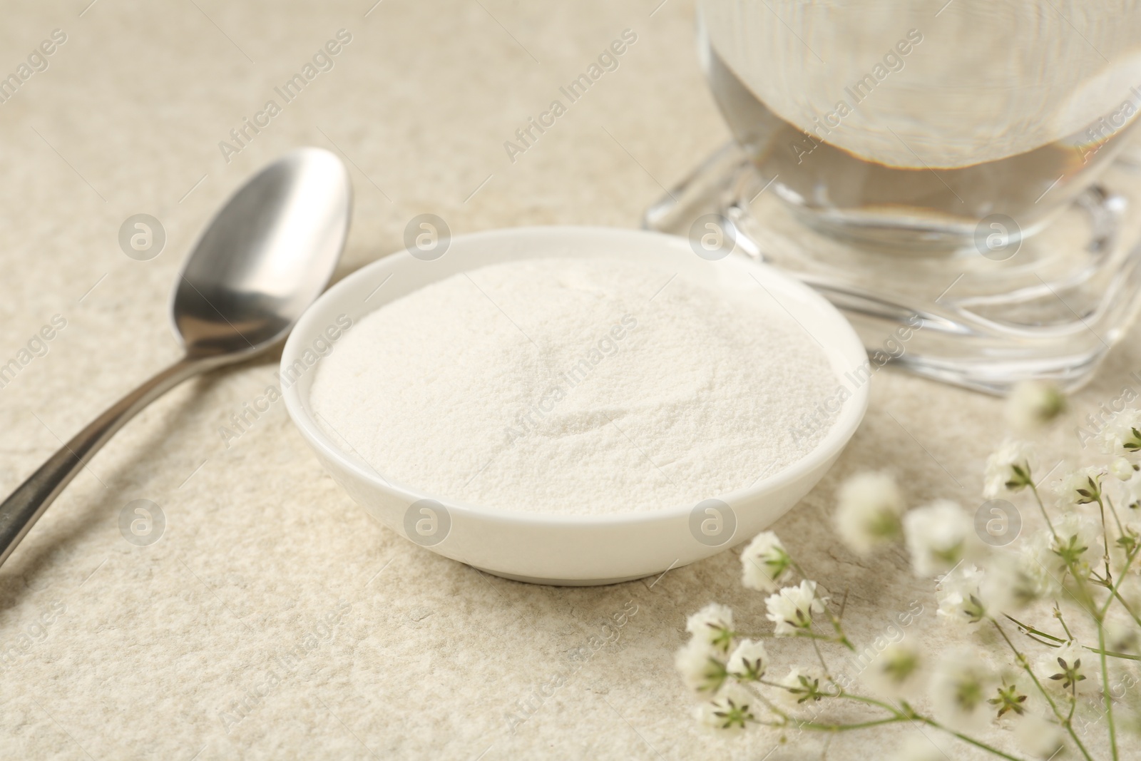 Collagen powder in bowl, spoon and gypsophila branches on light textured table, closeup Photo of Collagen powder in bowl, spoon and gypsophila branches on light textured table, closeup