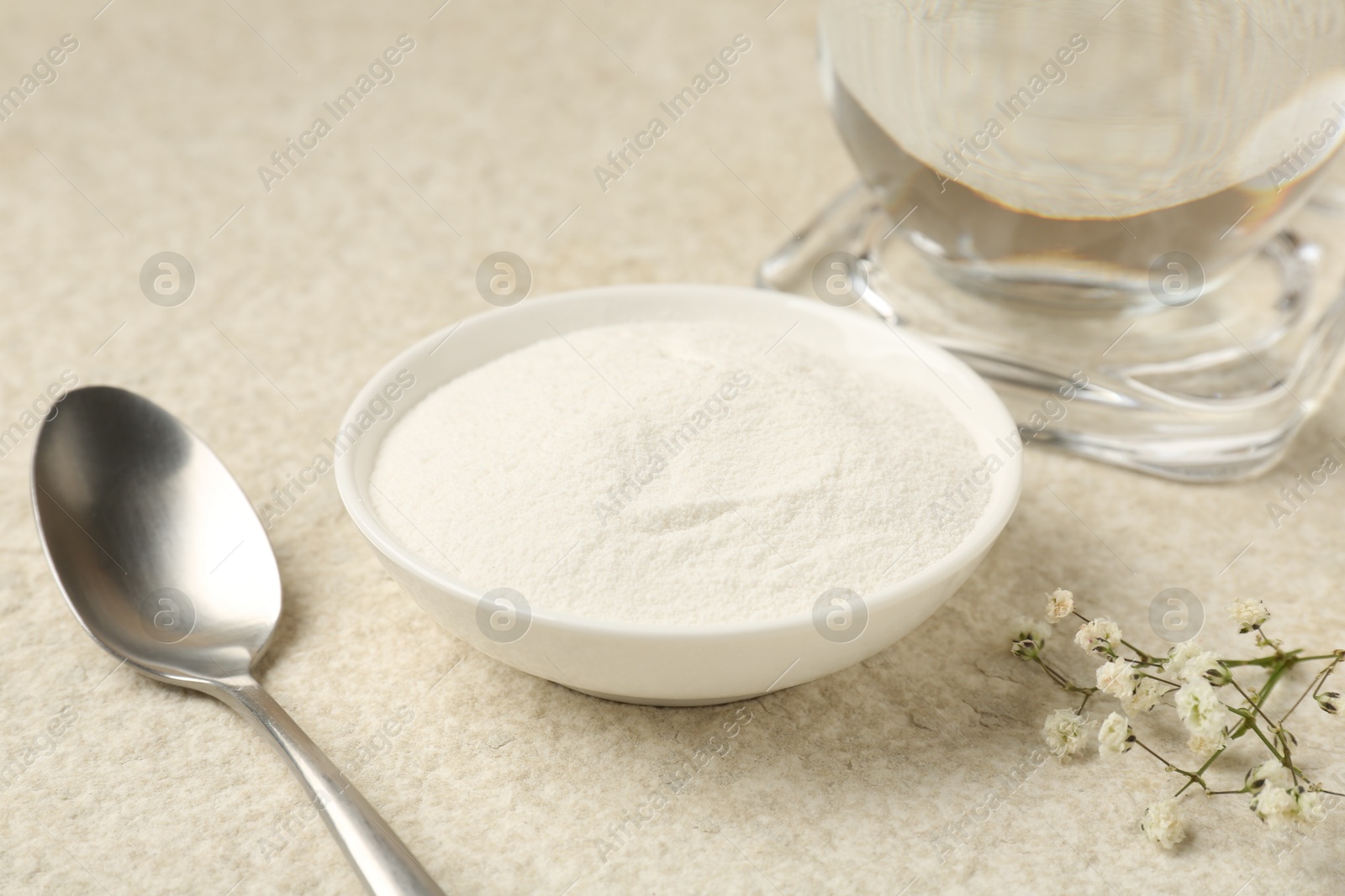 Collagen powder in bowl, spoon and gypsophila branches on light textured table, closeup Photo of Collagen powder in bowl, spoon and gypsophila branches on light textured table, closeup