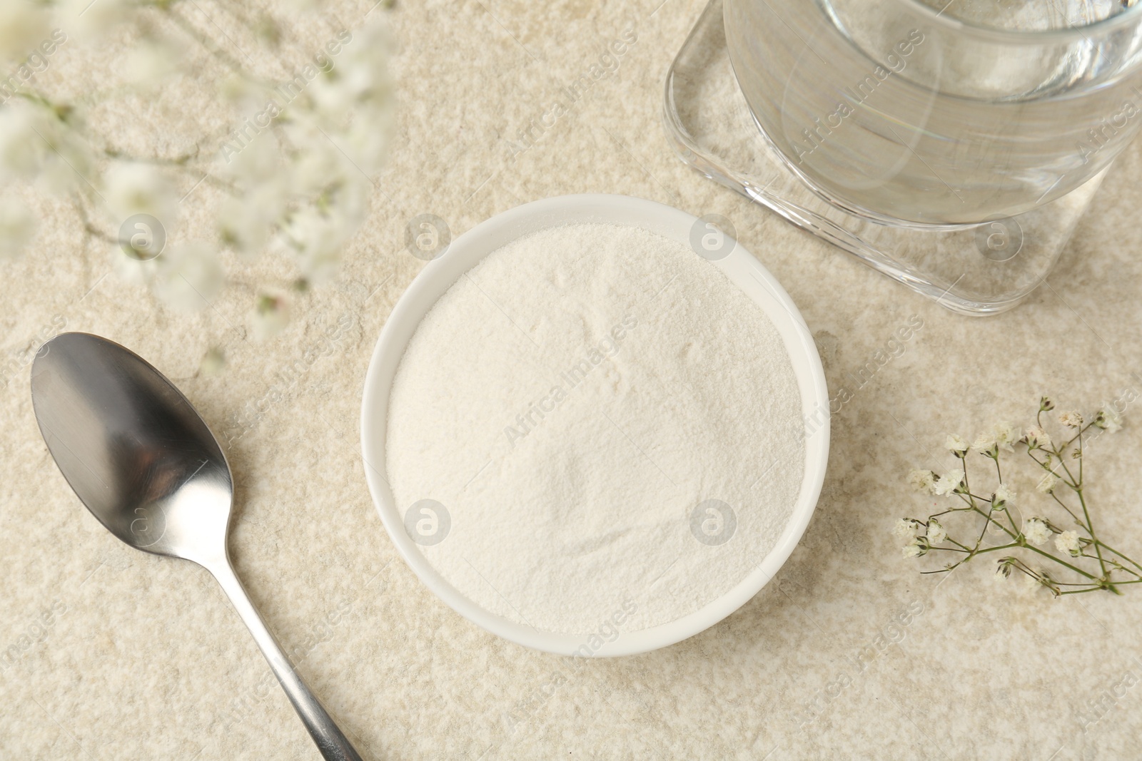 Collagen powder in bowl, spoon, glass of water and gypsophila branches on light textured table, flat lay Photo of Collagen powder in bowl, spoon, glass of water and gypsophila branches on light textured table, flat lay