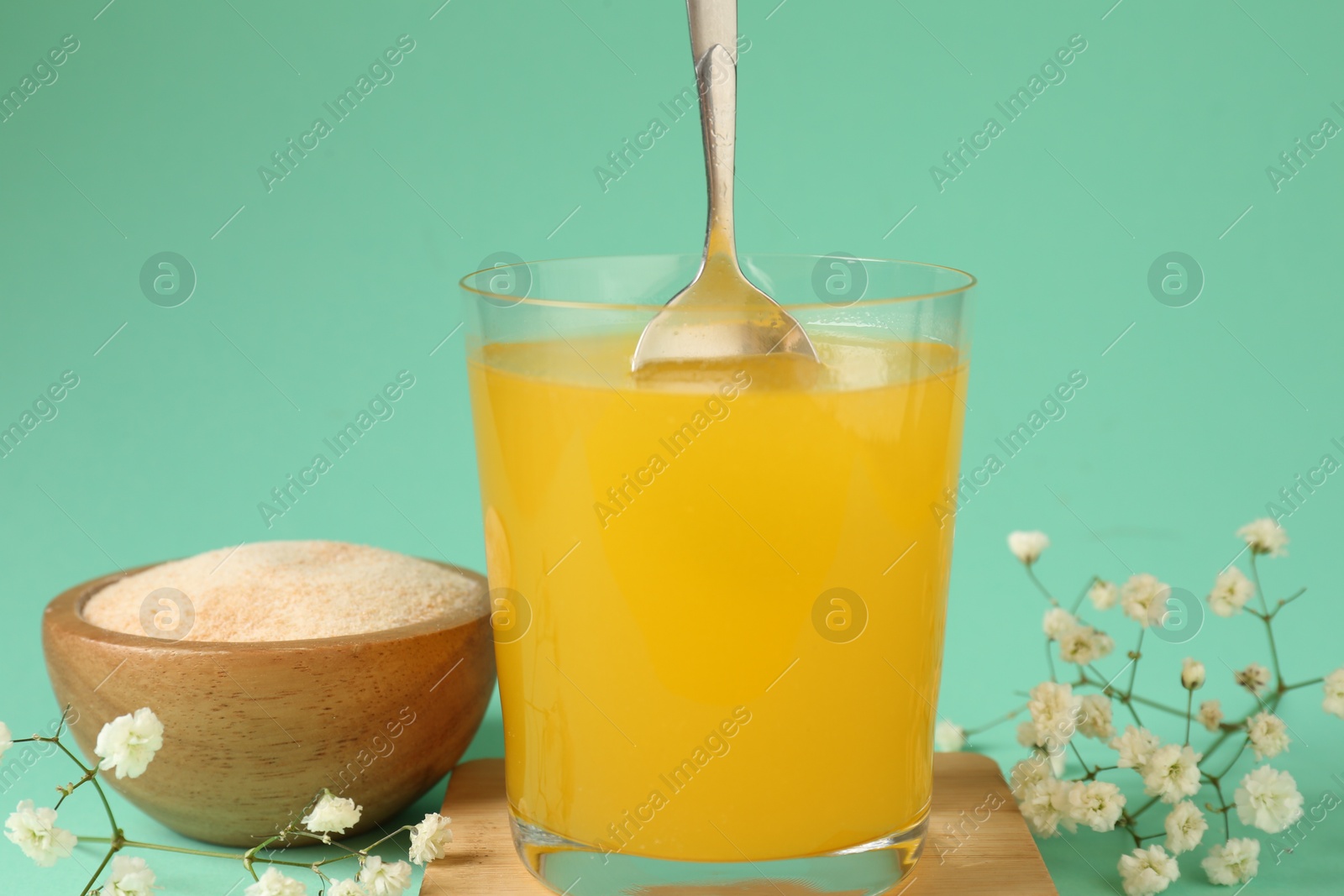 Stirring collagen powder in water on turquoise background, closeup Photo of Stirring collagen powder in water on turquoise background, closeup