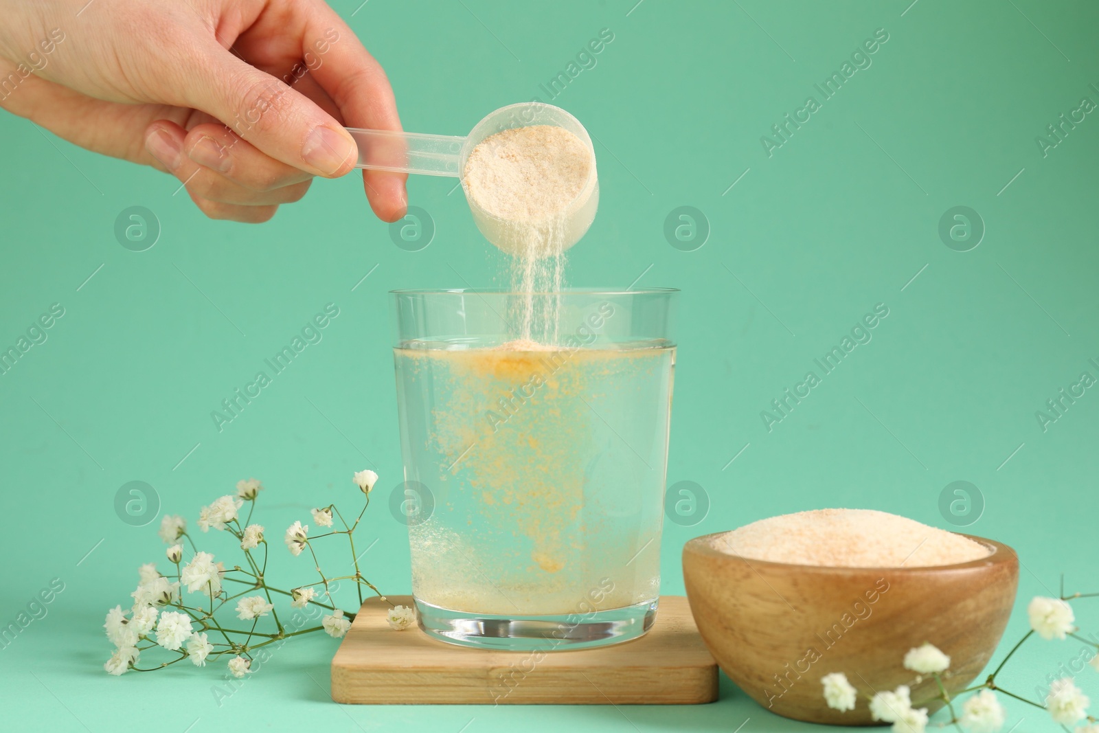 Woman adding collagen powder into glass with water on turquoise background, closeup Photo of Woman adding collagen powder into glass with water on turquoise background, closeup