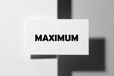 Image of Business card with word Maximum on white background, top view